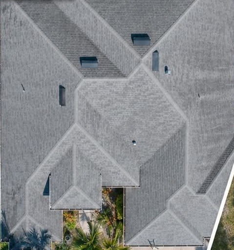 Aerial view of a hip roof with faded light gray asphalt shingles, labeled before in the original photo
